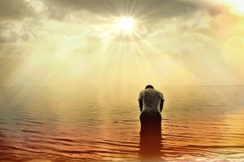 Imagen de un ser humano en el agua, inmerso en sus sombras y siendo bañado por la Luz Divina para el post Cómo trascender las sombras