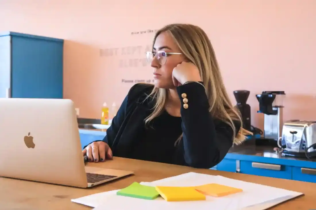 Imagen de una chica procrastinando en su escritorio, para el post Ley del Ritmo y procrastinación