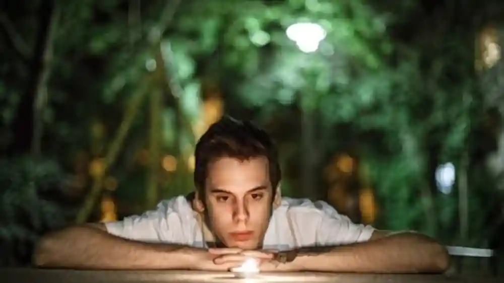 Imagen de un niño mirando la llama de una vela, como imagen destacada para el post Señales de despertar espiritual